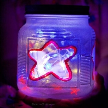 Frosted jar with star design and fairy lights inside.