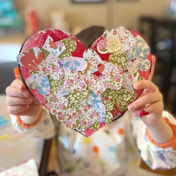 Heart paper craft held up by a child.