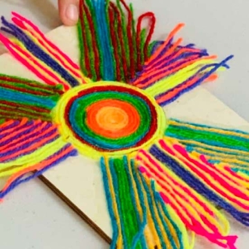 Partially completed Huichol yarn art project in the shape of a sun.